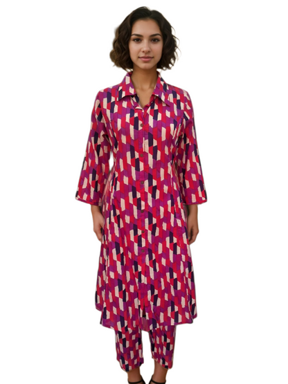 Woman wearing a colorful geometric patterned outfit standing.
