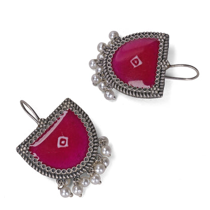 Pair of earrings with pink enamel and silver frames on a white background